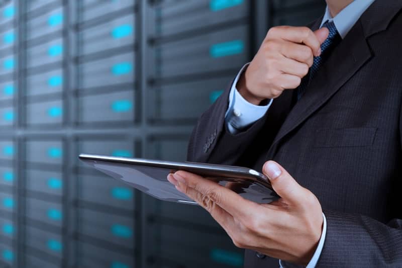 businessman using tablet computer and server room